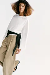 Jeans de tiro alto con pinzas delanteras, pernera ancha y fluida. Cuenta con cierre frontal de cremallera y botón, bolsillos frontales y bolsillos de plastrón en la parte trasera.