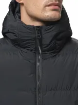 Campera puffer color verde militar, con diseño capitoneado, cuello alto y capucha integrada. Cuenta con cierre frontal, bolsillos laterales con cierre y puños con ojal para el pulgar.