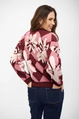 Buzo de tejido de punto con diseño de rombos y flores estampadas en tonos bordó, rosa y crema. Presenta cuello redondo, mangas largas y puños acanalados.