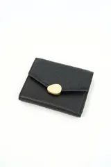Billetera de cuero sintético negro con solapa texturizada en símil cocodrilo y detalle de cierre metálico dorado.