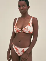 Conjunto de bikini con estampado floral color naranja y blanco, con corpiño con aro central y bombacha con aro lateral.