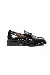 Mocasín de charol negro con diseño clásico y elegante, con detalle de herraje en la capellada.
