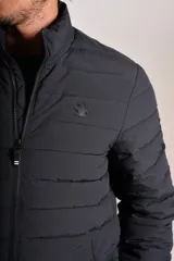 Campera acolchada negra con cierre frontal, cuello alto y diseño de costuras horizontales. Presenta un ajuste entallado y tejido exterior resistente al agua.