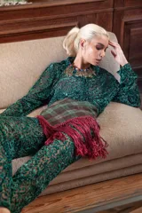 Pañuelo de lana con diseño a cuadros en tonos verdes y marrones, decorado con flecos largos en color bordó.
