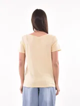 Remera color crema con estampado de figuras geométricas en blanco.