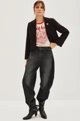 Saco de corte sastre entallado, color negro, con solapas clásicas, cierre frontal de un botón y mangas largas con detalle de botones en los puños.