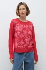 Sweater de punto color rojo con cuello redondo, mangas largas y bordado floral en tono rosado en la parte frontal.