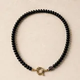 Collar compuesto por varias hileras de piedras naturales de calcedonia pulida en tonos verde, negro y bordó, con detalle de cuenta de cristal de Murano y cierre marinero con baño dorado.