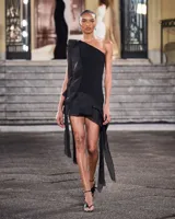 Vestido corto blanco de crepé y organza, con un solo hombro, diseño entallado y volados con tiras colgantes.