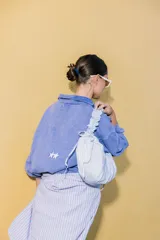 Bolso de nylon negro con estampado de lunares blancos, diseño plisado y cierre superior.