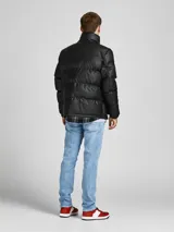 Campera puffer negra de cuero sintético con cierre frontal y cuello alto.