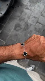 Conjunto de collar y pulsera con diseño de tréboles de ónice negro enmarcados en plata, unidos por una cadena rolo de acabado brillante.