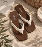 Sandalias bajas con punta cuadrada, base marrón y tiras anchas en color beige.