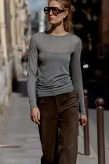 Camiseta de manga larga color beige, con cuello redondo y detalle de camiseta interior en el mismo tejido. Tiene un bajo asimétrico y corte slim fit.