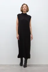 Vestido midi de tejido de punto, color negro, sin mangas, con cuello alto y tajo frontal en la falda.