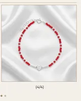 Pulsera de plata 925 con cuentas de cristal facetado en color rojo y un dije central en forma de corazón plateado.