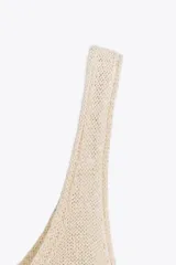 Top de punto color beige claro con escote redondo y tirantes finos.