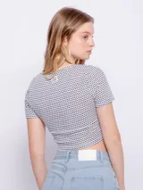 Top de manga corta con escote en V y fruncido ajustable con lazo en el centro, de tela texturizada con estampado de puntos pequeños.