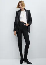 Pantalón tipo jeans de corte skinny y tiro alto, con acabado efecto encerado. Cuenta con diseño de cinco bolsillos, trabillas para cinturón y cierre frontal con cremallera y botón.