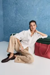 Camisa blanca de algodón, de calce relajado, con cuello camisero, frente abotonado y mangas largas abullonadas.