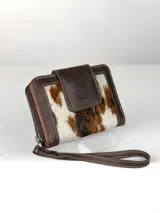 Mini billetera de cuero con diseño combinado de cuero liso marrón y cuero con pelo vacuno estampado. Cuenta con cierre de solapa con broche magnético y logo de búho grabado, además de una correa de muñeca extraíble.