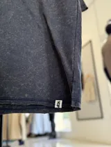 Remerón de corte oversize en tejido rústico con efecto gastado, cuello redondo y mangas cortas.