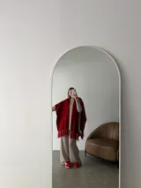 Ruana negra de tejido liviano con terminación de flecos en el ruedo y mangas amplias.