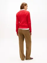 Sweater Tommy Hilfiger de punto con diseño de cable, color rojo, con cuello redondo, manga larga y el logo de la marca bordado en el pecho.