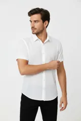Camisa de algodón blanca de manga corta, con cuello camisero y cierre frontal de botones.