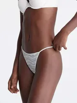 Colaless blanco con encaje elástico transparente y tiras delgadas.