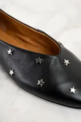 Chatitas de cuero negro con apliques de estrellas plateadas.