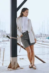 Blazer de lino blanco con solapas y detalles de volados en los puños, de corte recto y clásico.