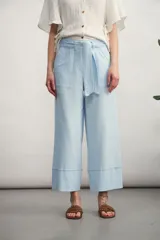 Pantalón de corte culotte en color celeste claro, con cintura alta, lazo ajustable en la cintura y dobladillo ancho en la parte inferior.