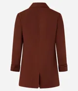 Blazer de sastrería color bordó, de corte oversized y largo, confeccionado en crepé. Presenta solapas clásicas, bolsillos frontales y detalle de pliegues en los puños.