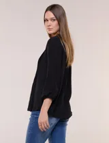Blusa celeste de silueta suelta y textura liviana, con escote en V, cuello mao y cierre frontal de botones. Cuenta con alforzas verticales en el pecho y mangas tres cuartos con puños elastizados y detalle de galón calado.