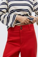 Pantalón en lona de algodón con cintura de tiro alto y cierre con botones. Piernas rectas con raya adelante y atrás, y bolsillos atrás de parche.