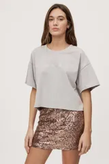 Falda corta de tiro medio con diseño de lentejuelas negras y silueta recta.