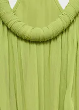 Vestido maxi largo de tejido plisado color verde, con tirantes finos, cuello escotado y cintura fruncida con elástico.