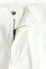 Jeans de denim blanco off-white, de tiro alto y corte acampanado con botamanga ancha y raya marcada al frente.