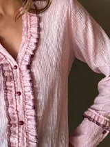 Camisa negra de manga larga con detalle de volados en el frente y puños.