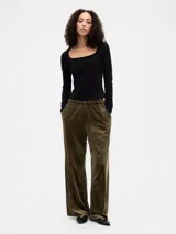 Pantalón de corte recto y holgado confeccionado en terciopelo, con cintura elástica y bolsillos laterales.