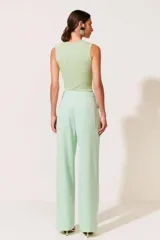 Pantalón de vestir verde menta, de corte palazzo, con cintura alta y pinzas frontales.