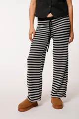 Pantalón tejido a rayas horizontales negras y grises, con forro interior y cordón ajustable en la cintura.