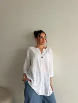 Blusa de viscosa color blanco, de corte amplio y largo, con escote en V y un botón frontal visible.