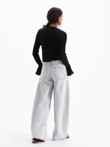 Jeans amplio de denim color celeste grisáceo, confeccionado en algodón, con tiro medio, fit holgado y efecto bombé hacia el ruedo.