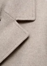 Abrigo midi de corte recto con cierre de doble botonadura, cuello con solapas de muesca y bolsillos laterales. Cuenta con manga larga y forro interior.
