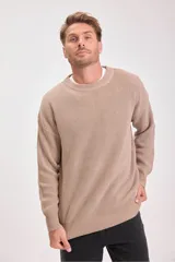 Sweater de punto grueso en color marrón, con cuello redondo y diseño de textura acanalada. Presenta un corte holgado y mangas largas.