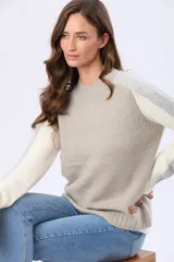 Buzo tejido de punto con cuello redondo y mangas largas. Presenta un diseño de bloques de color con franjas en tonos contrastantes a lo largo de las mangas y un detalle de etiqueta de cuero en el ruedo.