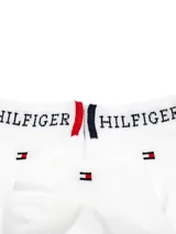 Medias tobilleras blancas Tommy Hilfiger con la palabra "Hilfiger" y el logo de la marca bordados en negro.