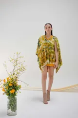 Ruana de lana merino con estampado abstracto en tonos amarillo, verde y marrón.